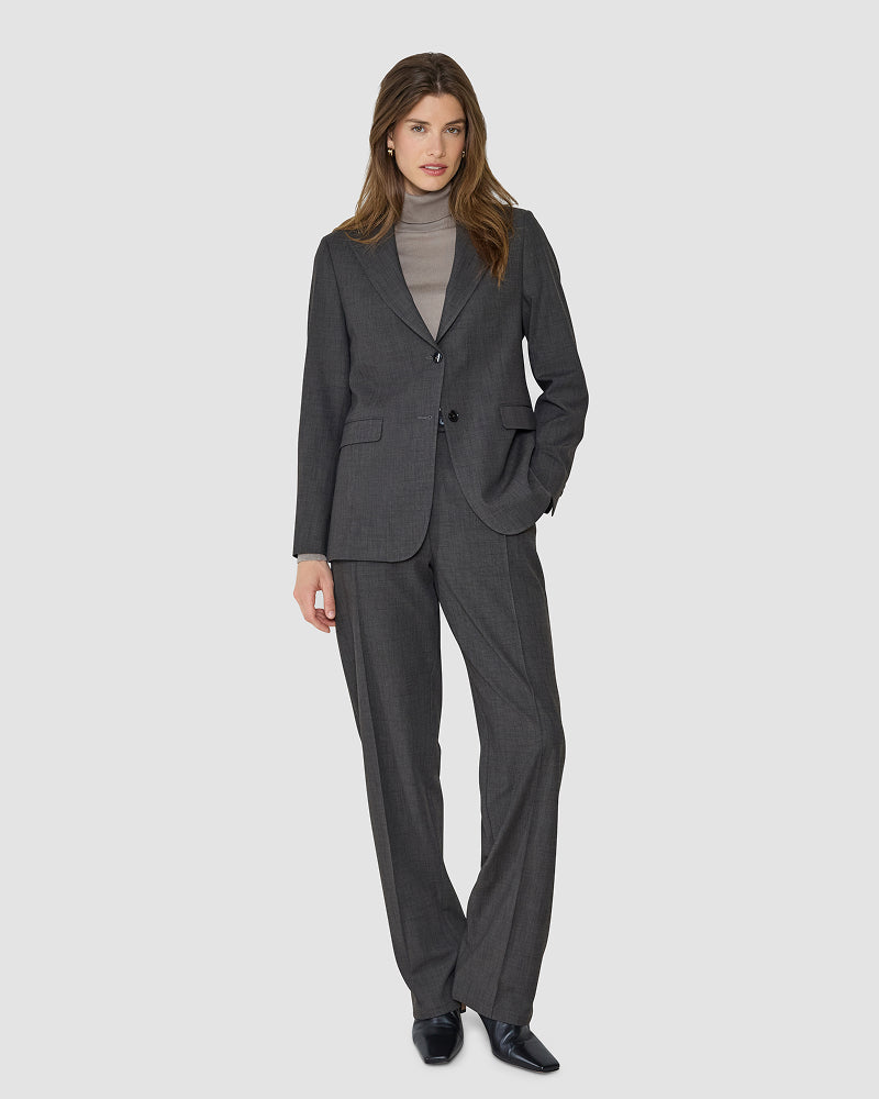 A woman models the Nara Suit Straight Cool Brown worn over a beige turtleneck.